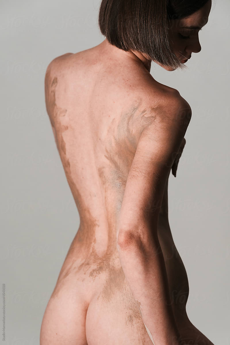 Naked woman covered with organic clay