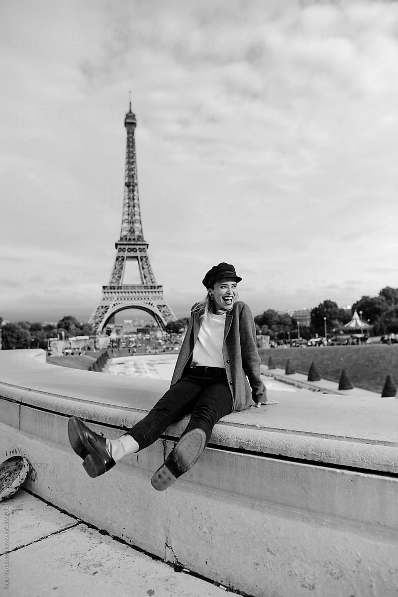 stylish woman having fun in front of the eiffel tower in black and white