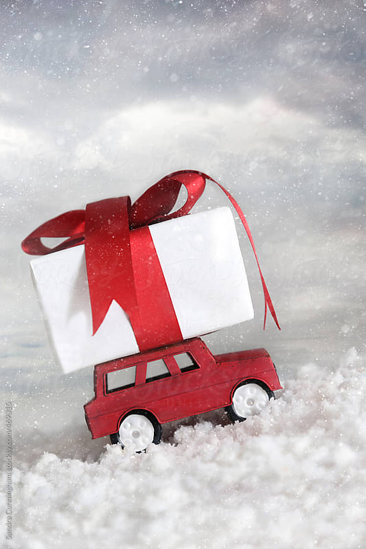 Car going up snowy hill with gift