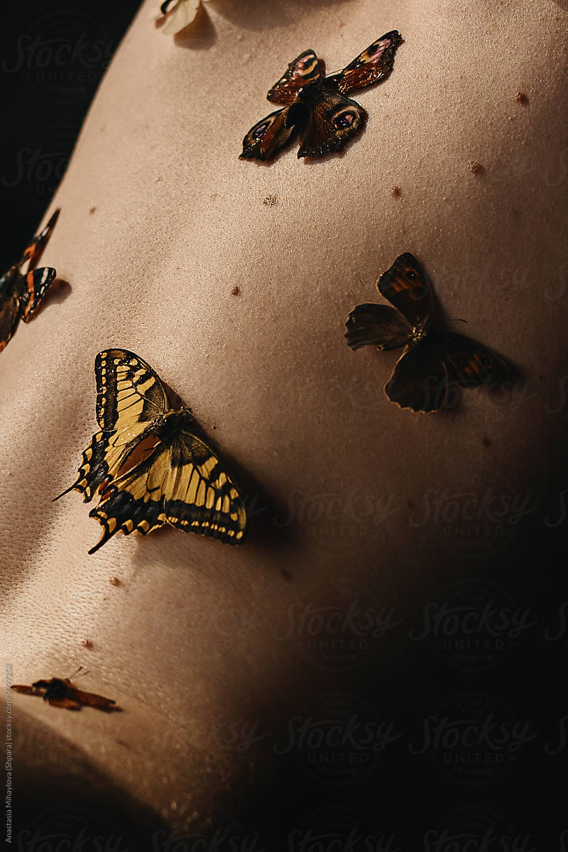 Close up photo of the woman's skin texture with moles and butterfly