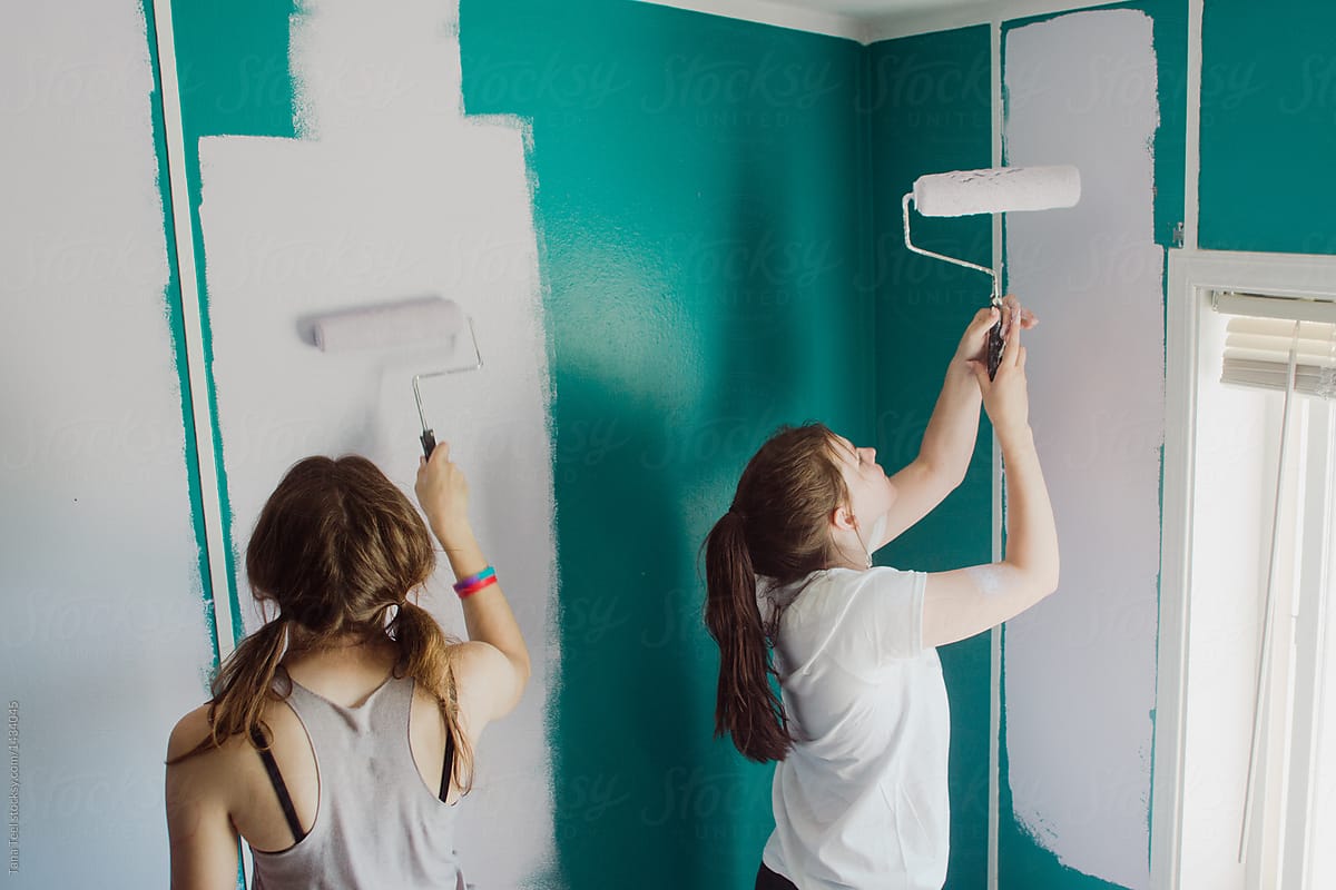 teenagers painting walls in a room