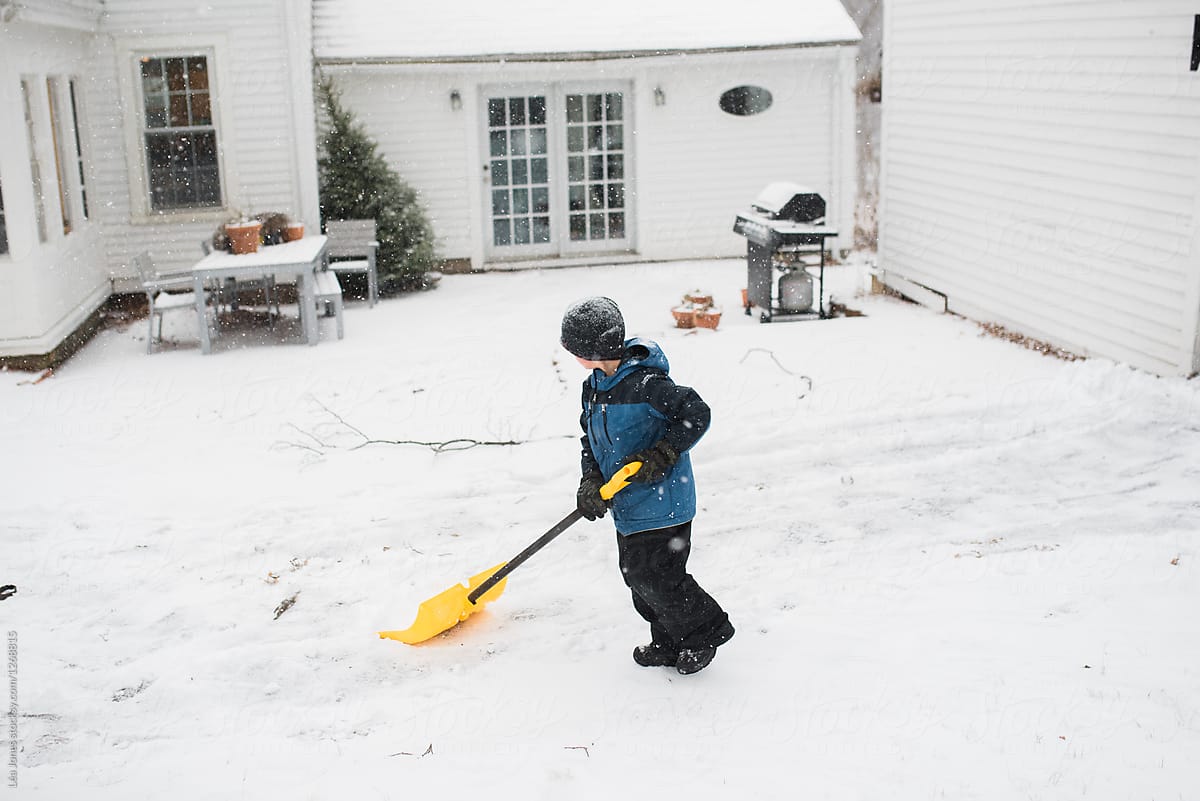 boy playing in the snow with shovel and wagon