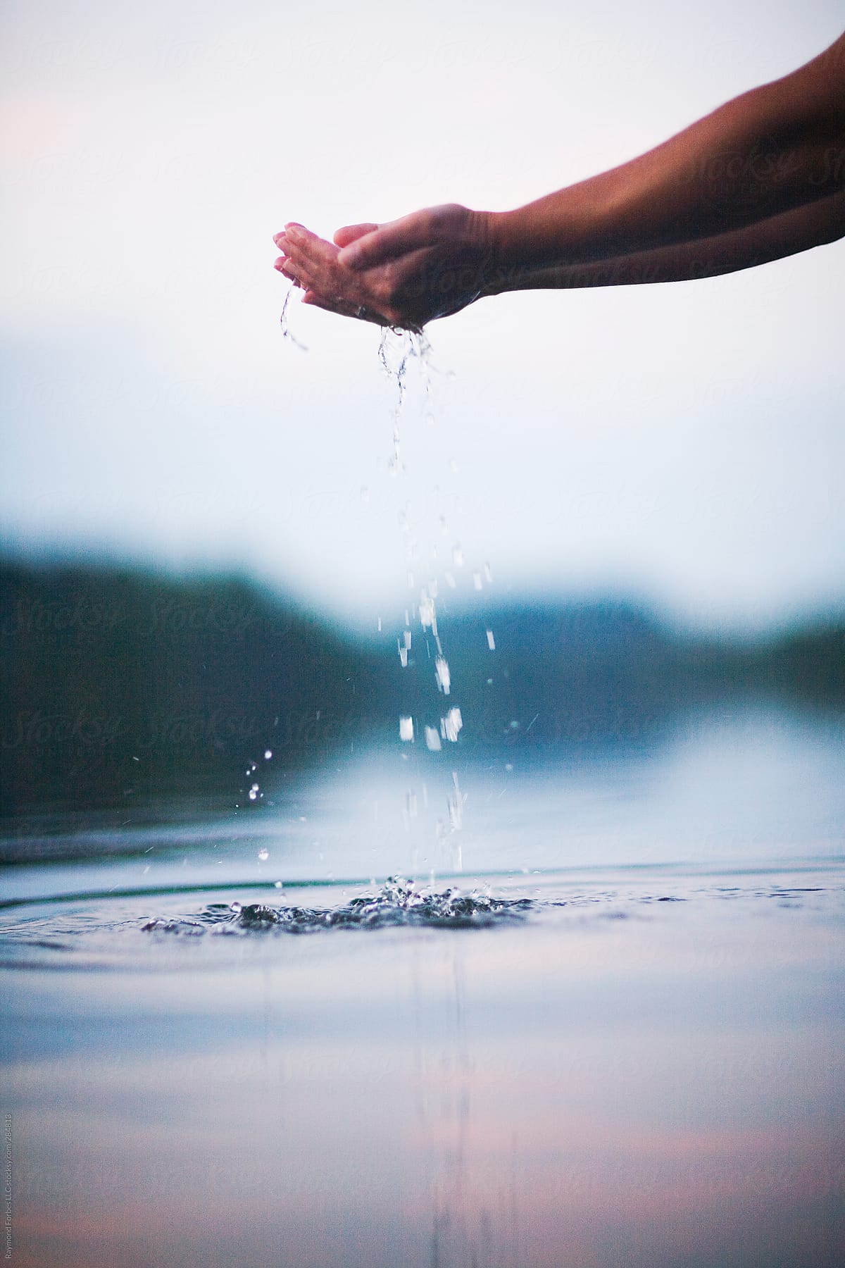 Holding Water in Hands at Lake with Water Droplets