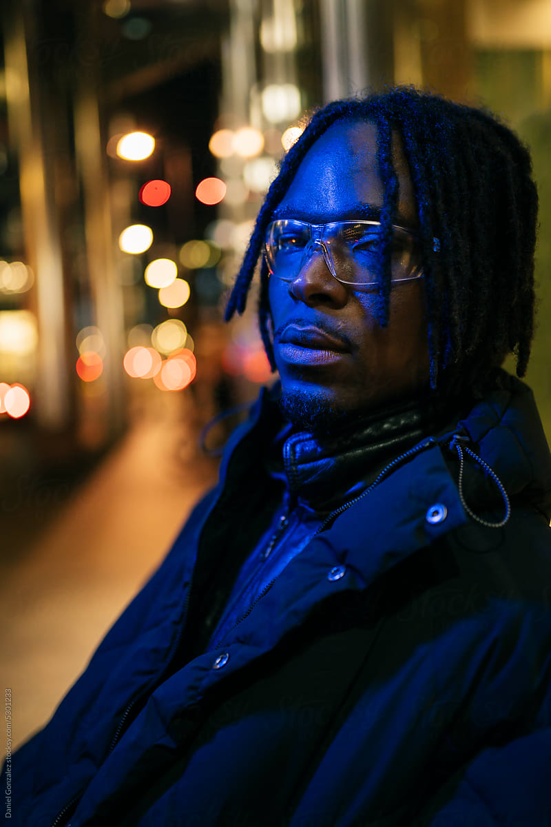 African American man in glasses on street at night