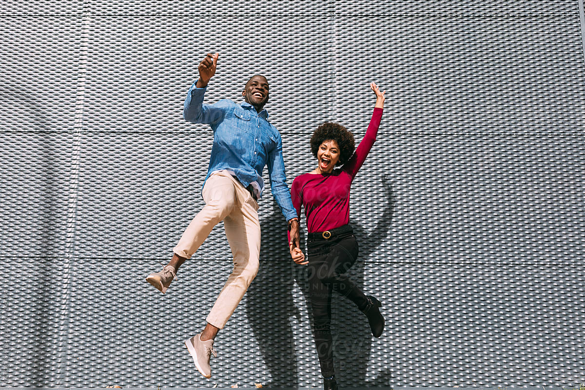 Cheerful black couple jumping
