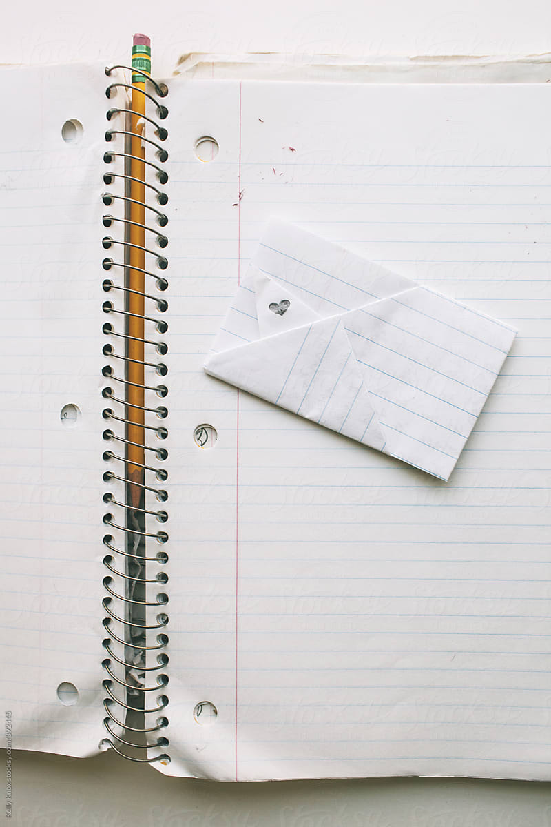 folded love note on an open notebook with pencil