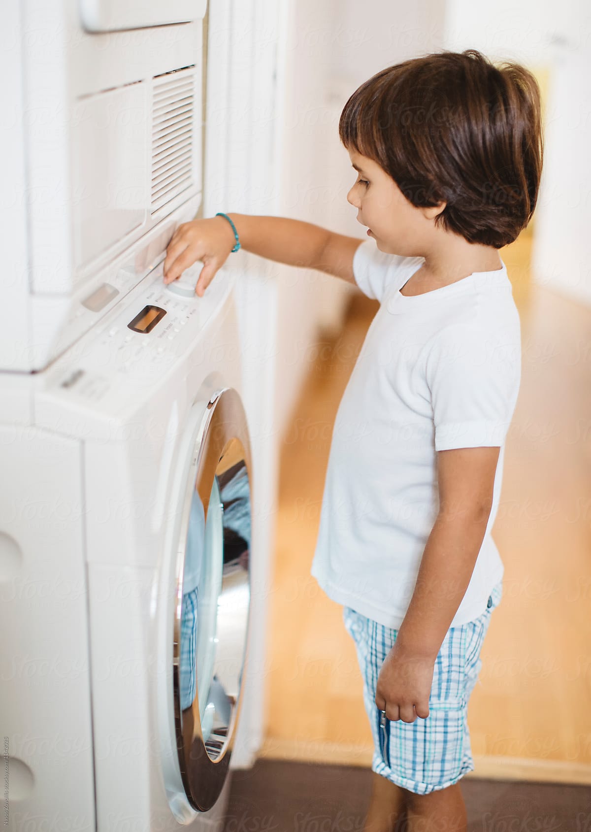 5 year old boy in front of a washing machine