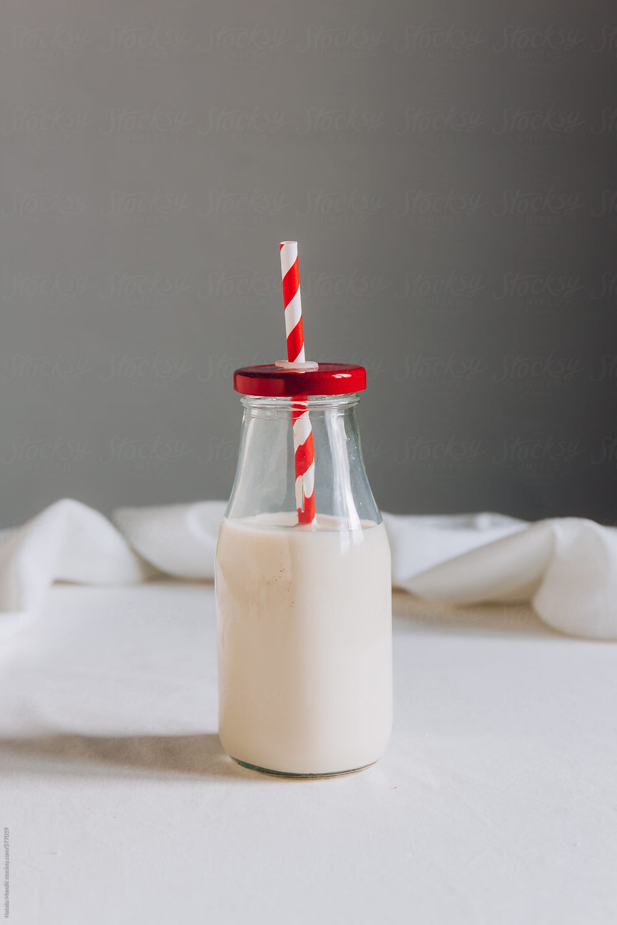 Milk in a bottle with red and white straw