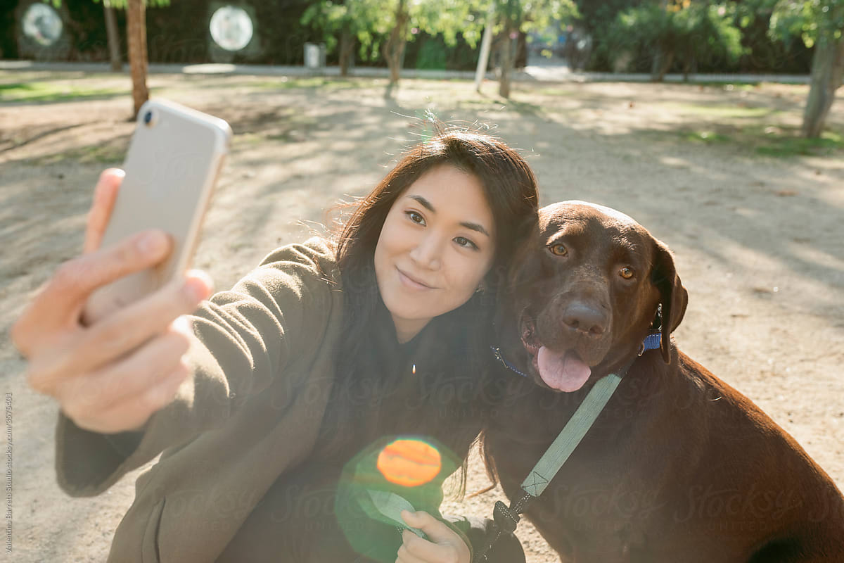 asian woman and her labrador dog taking a selfie