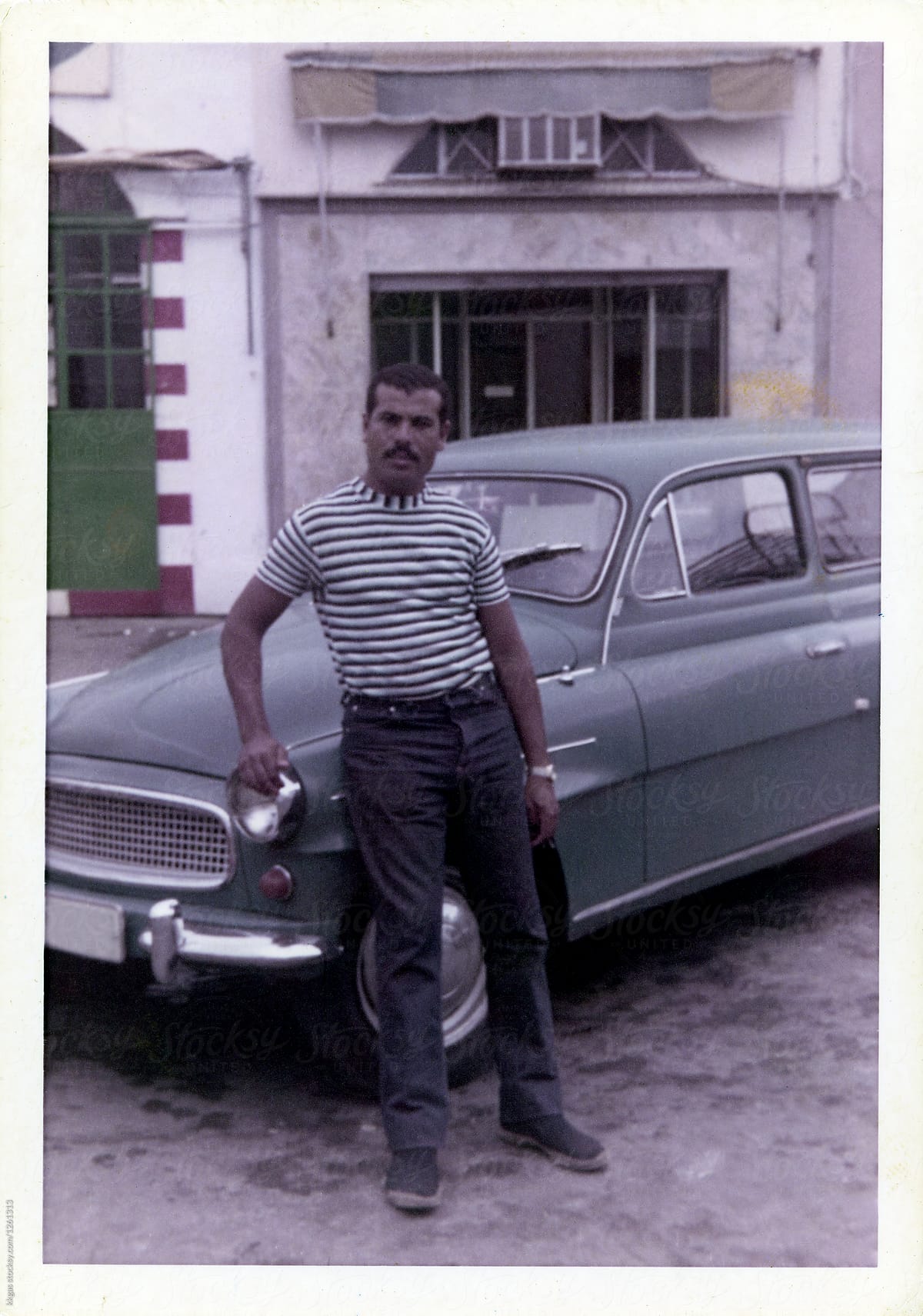 1970\'s colour photo of a man leaning against his car.