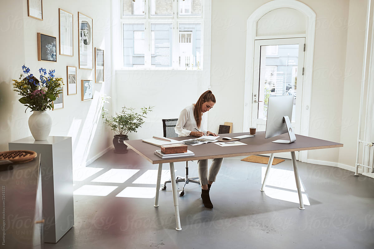 Young Female Architect Sketching New Designs At Her Office Desk By