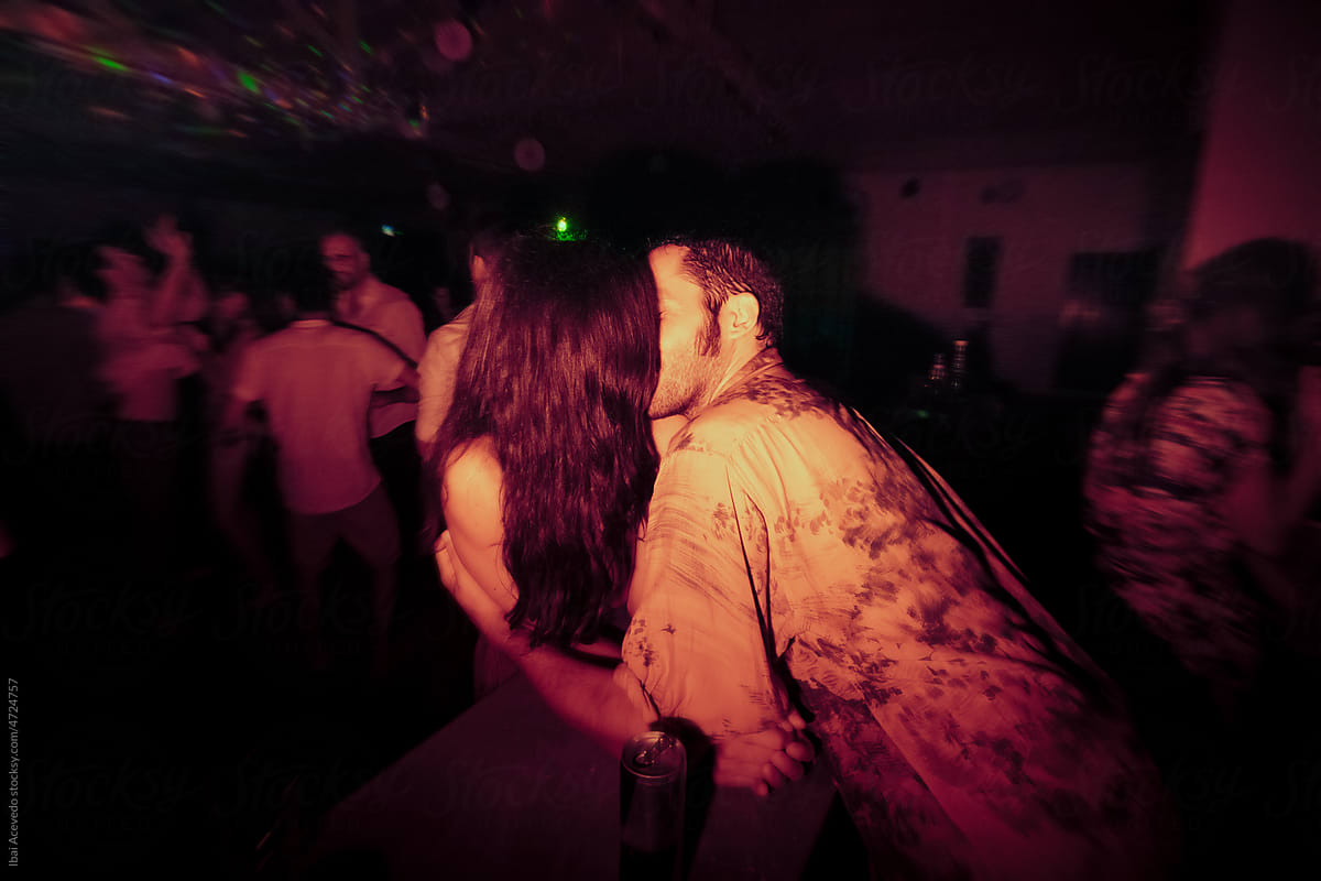 Anonymous lovers kissing at night bar party