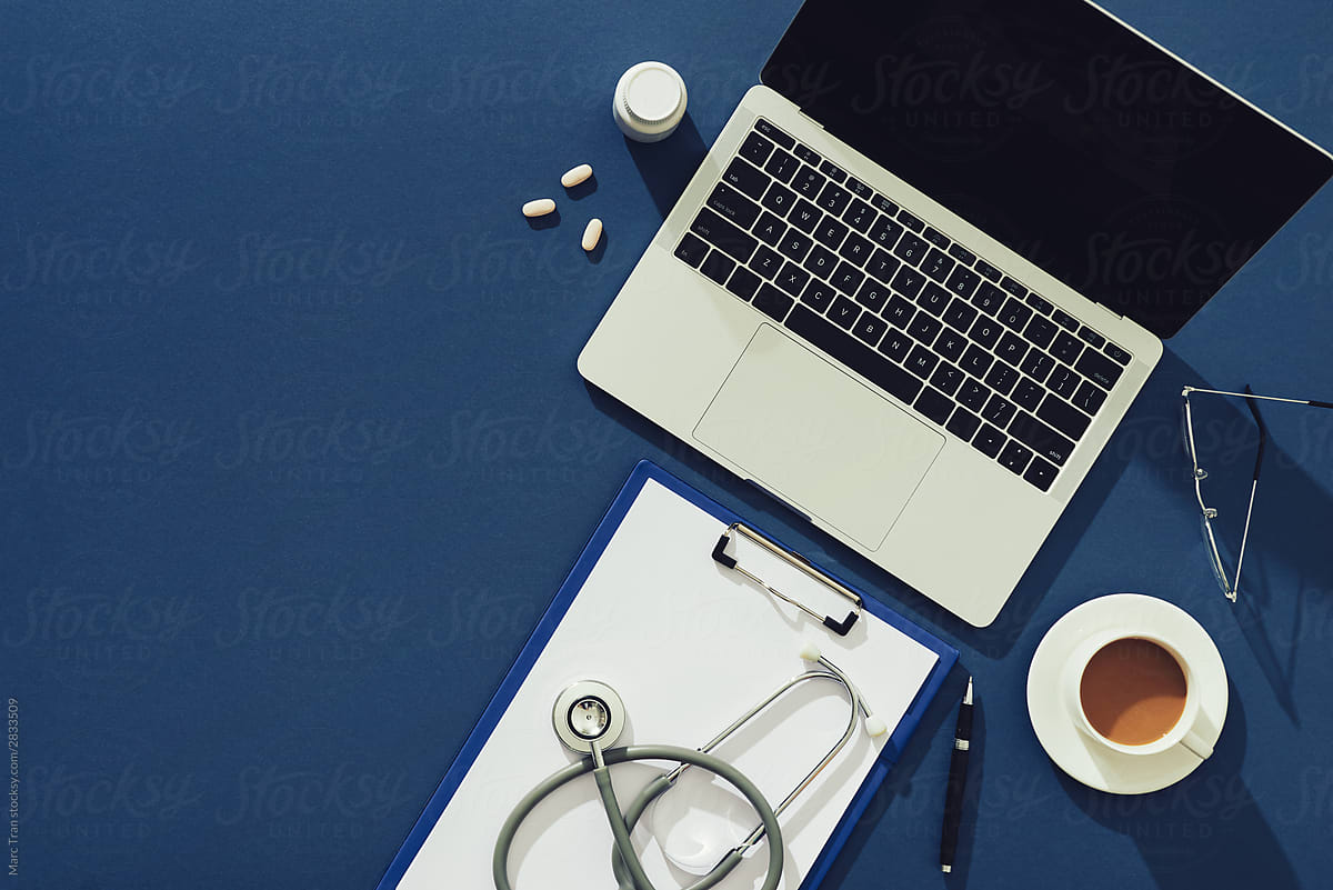 Stethoscope in doctors desk with tablet and coffee cup