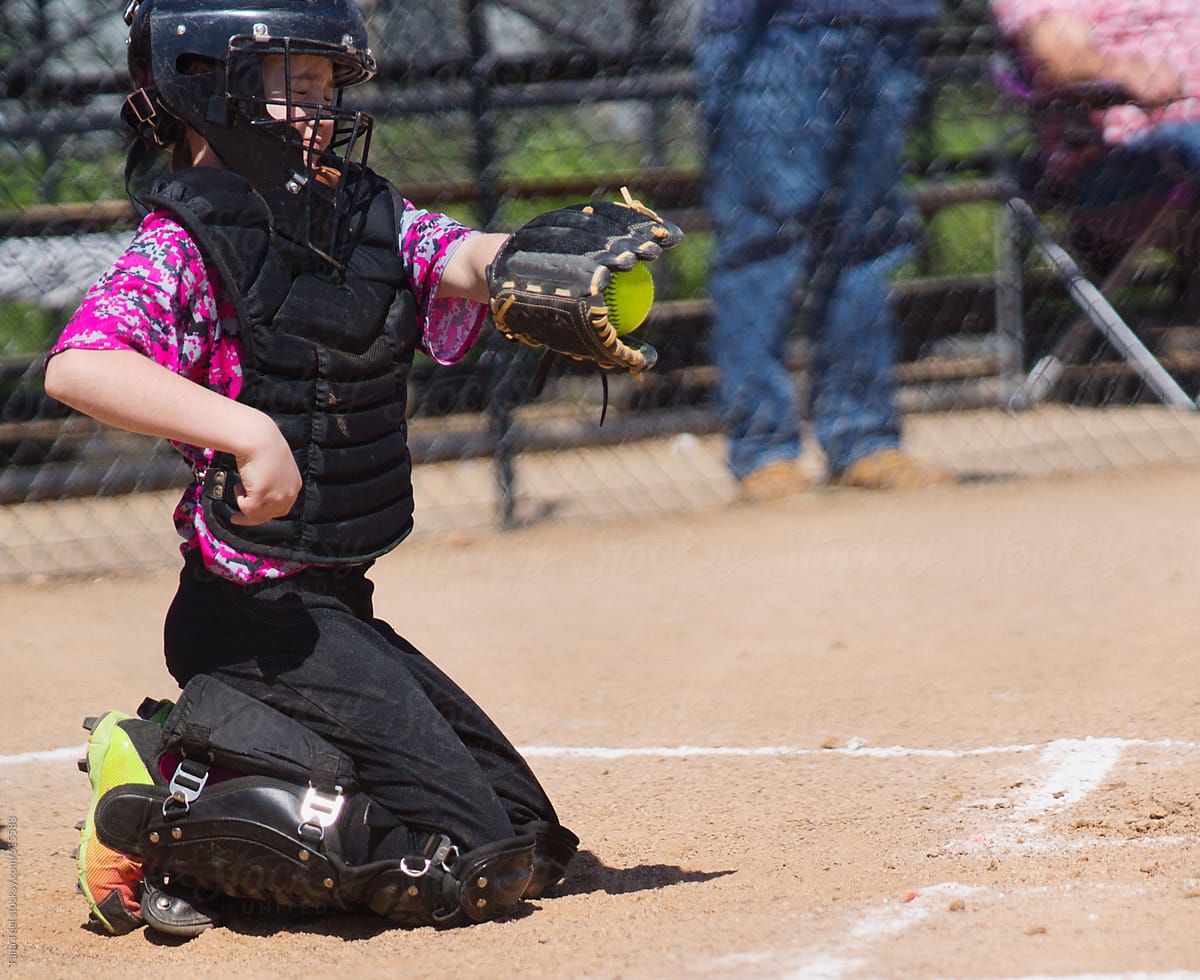 Softball catcher closes her eyes while catching softball