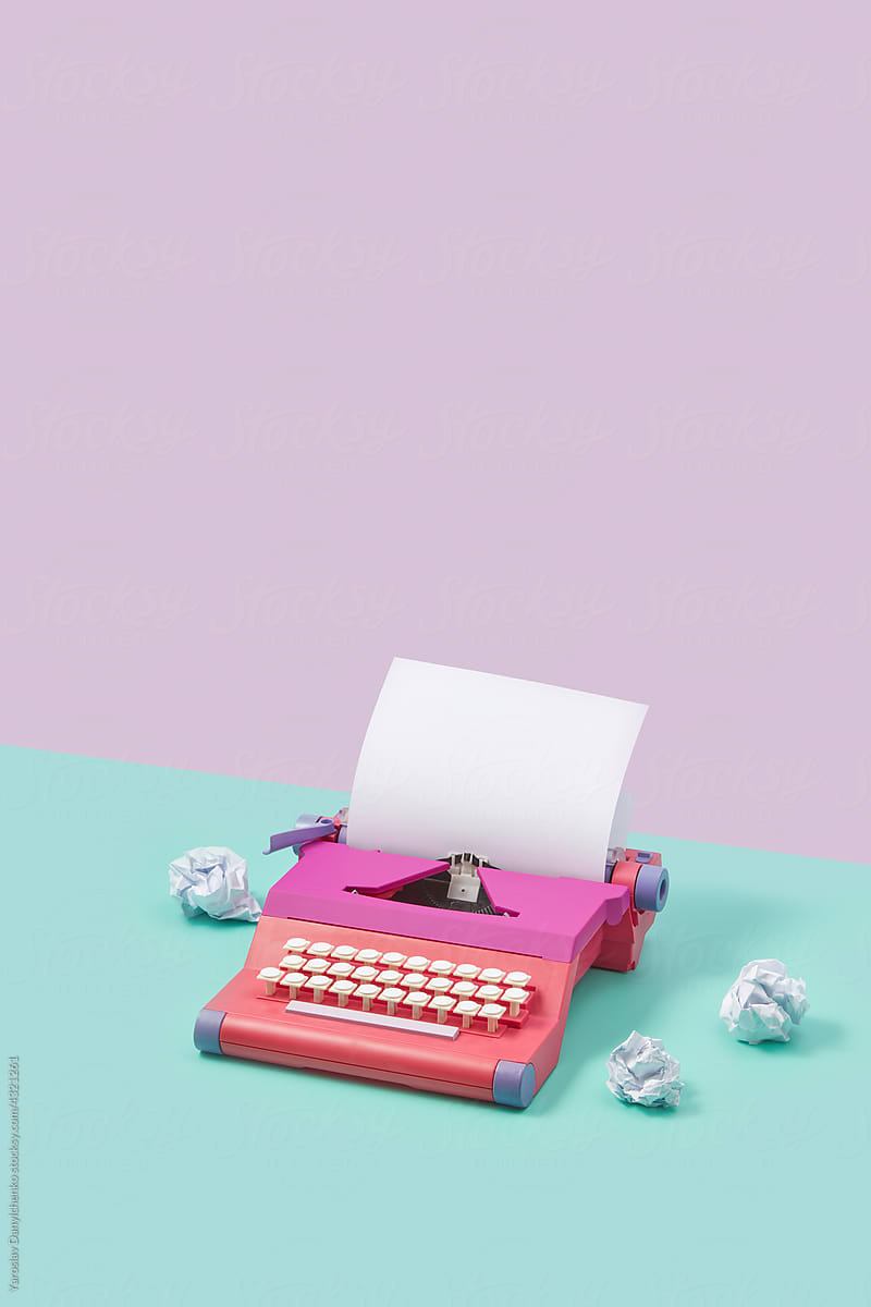 Pink typewriter and crumpled papers