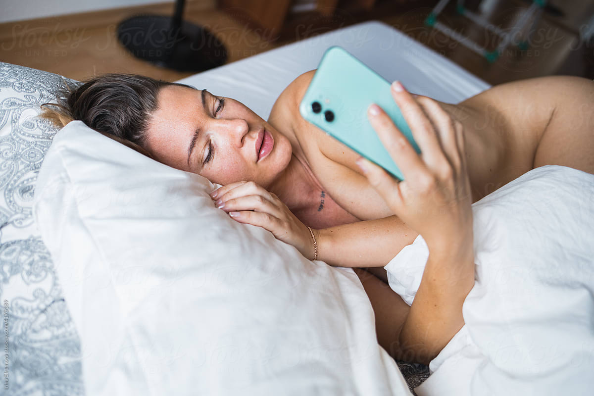 Woman in bed on the phone reading a message