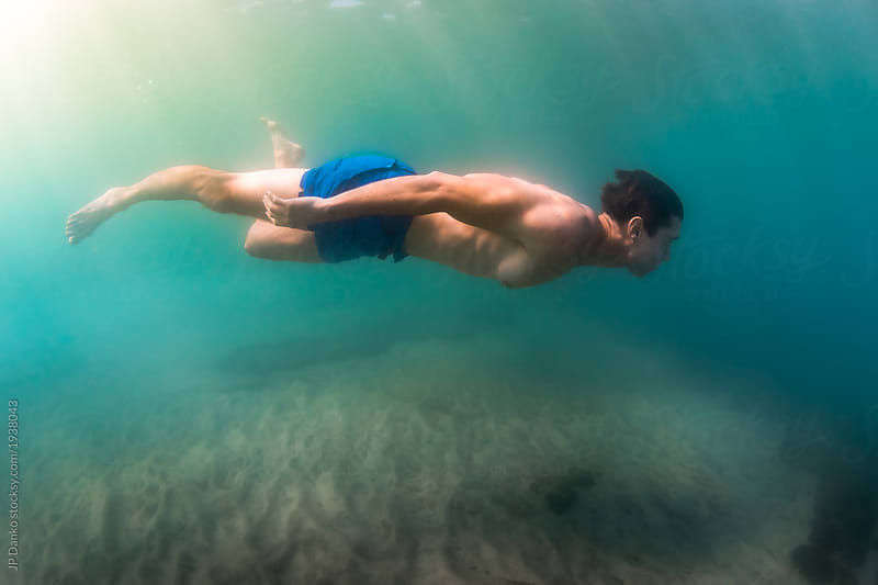 Man holds his breath and swims underwater