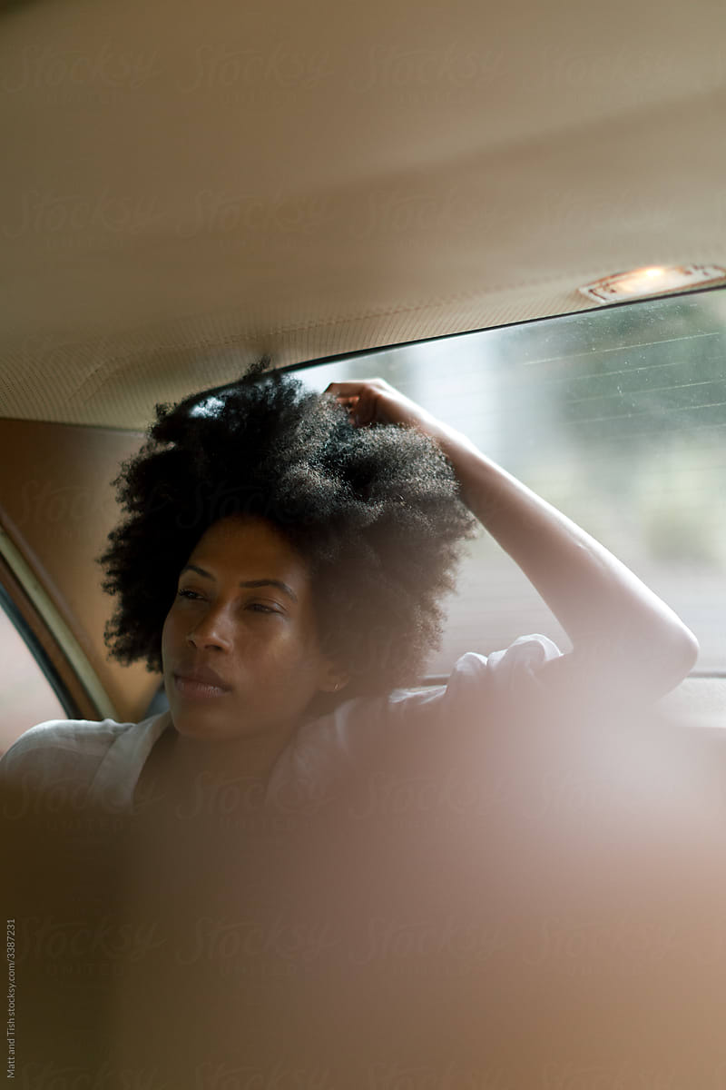 Black Woman sitting in the back of a White Vintage Car