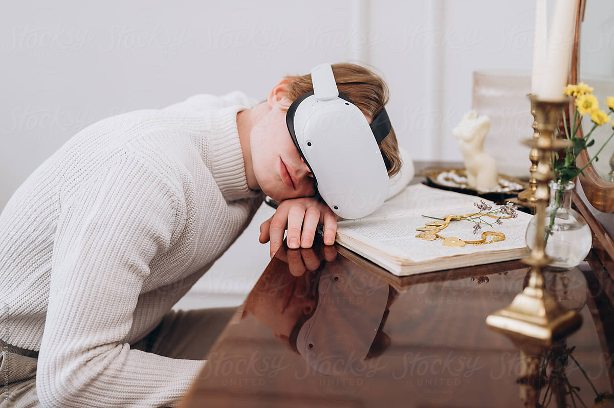 Young man in VR glasses lying on table