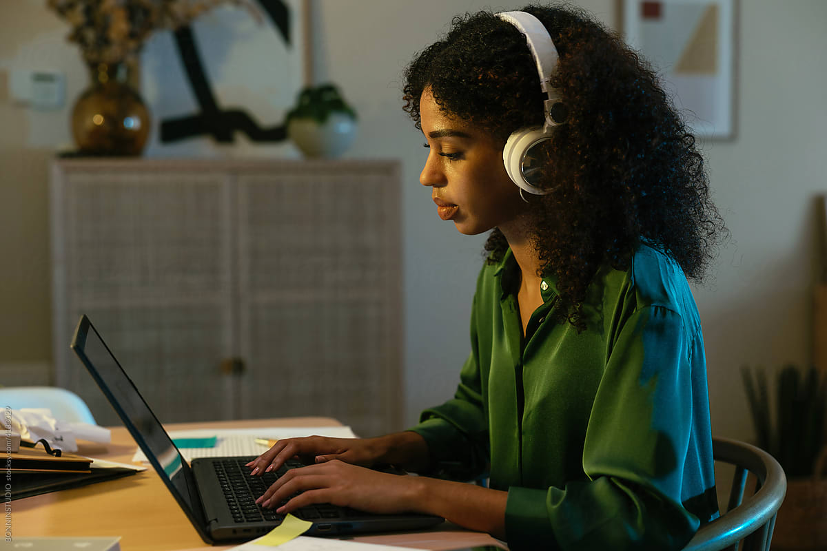 Black woman in headphones using netbook