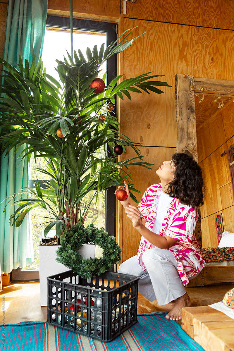 Woman decorating potted palm at home