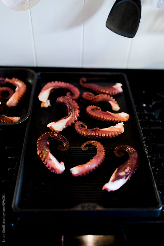 Close up of octopus tentacles grilling on okate on stove