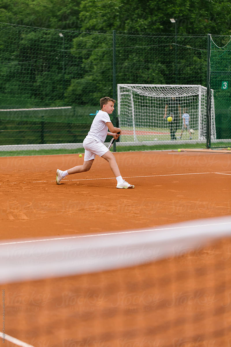 Male Kid Practising Tennis Outdoors