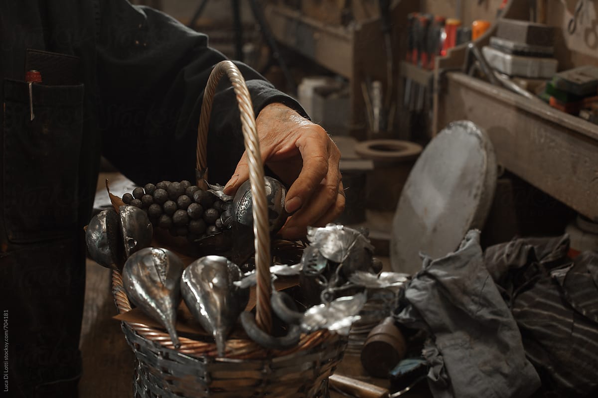 Blacksmith arranging fruit shaped metal items