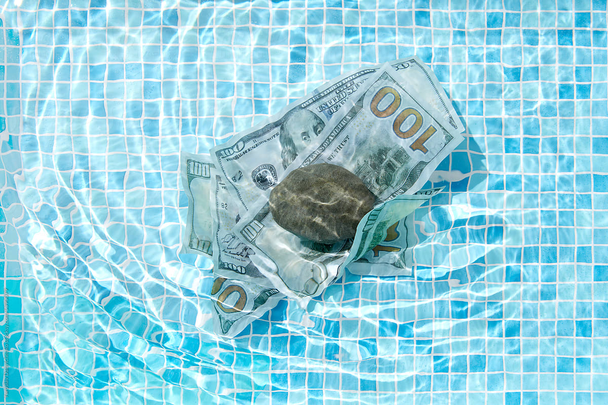 100 dollar banknotes in pool\'s water.