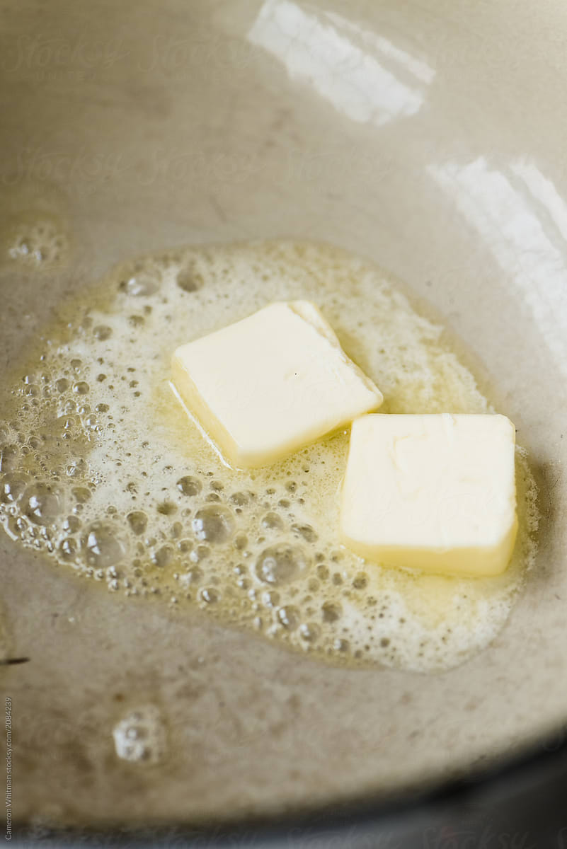 Butter pats melting in a pan