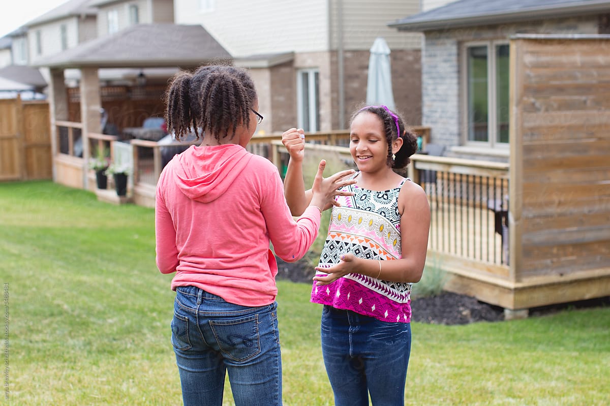 Two tween children playing a hand game outdoors
