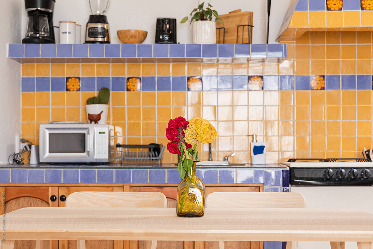 Kitchen with yellow and blue tiles equipped with appliances