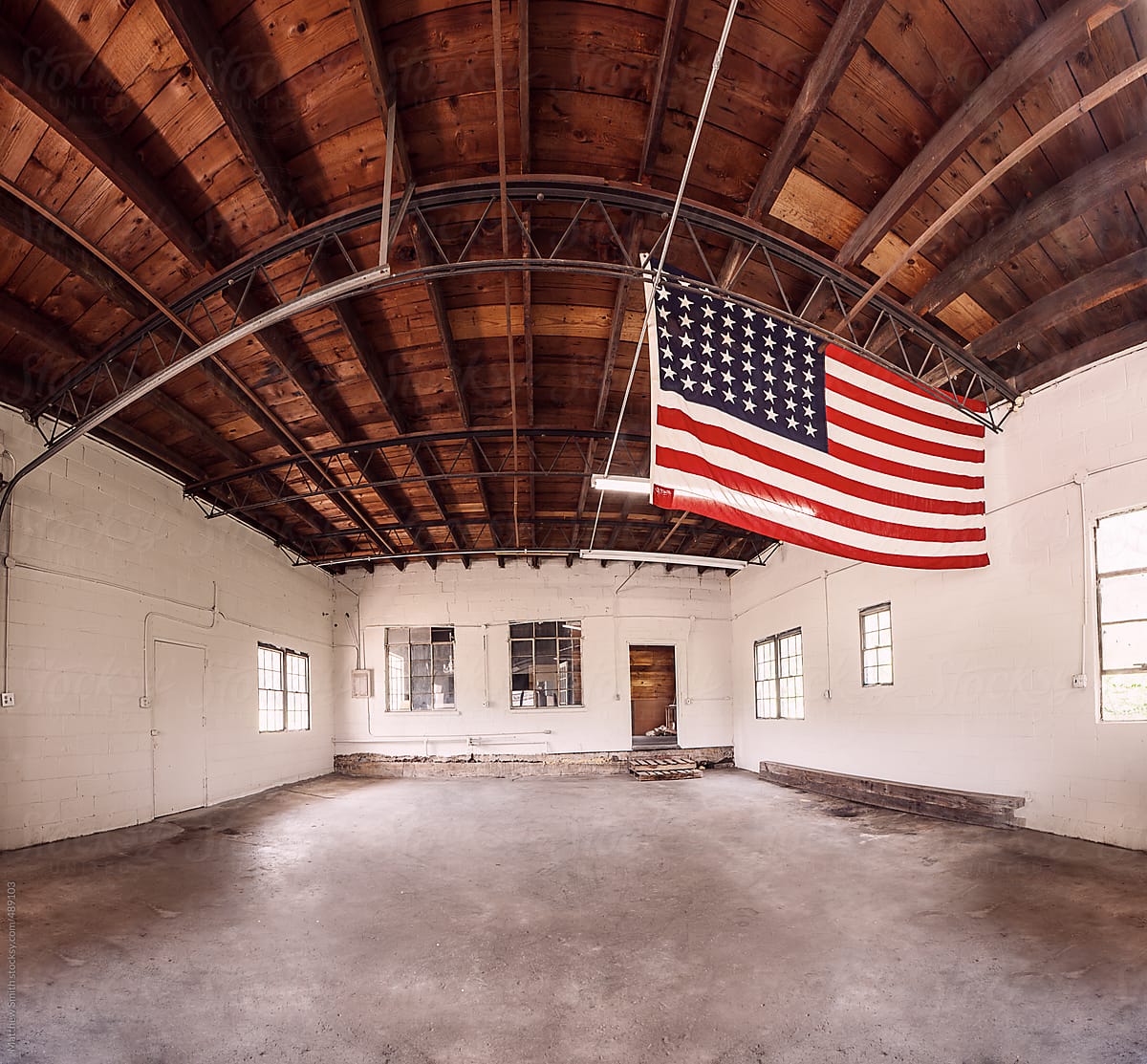 An Empty Building With An American Flag Hanging From The Ceiling.