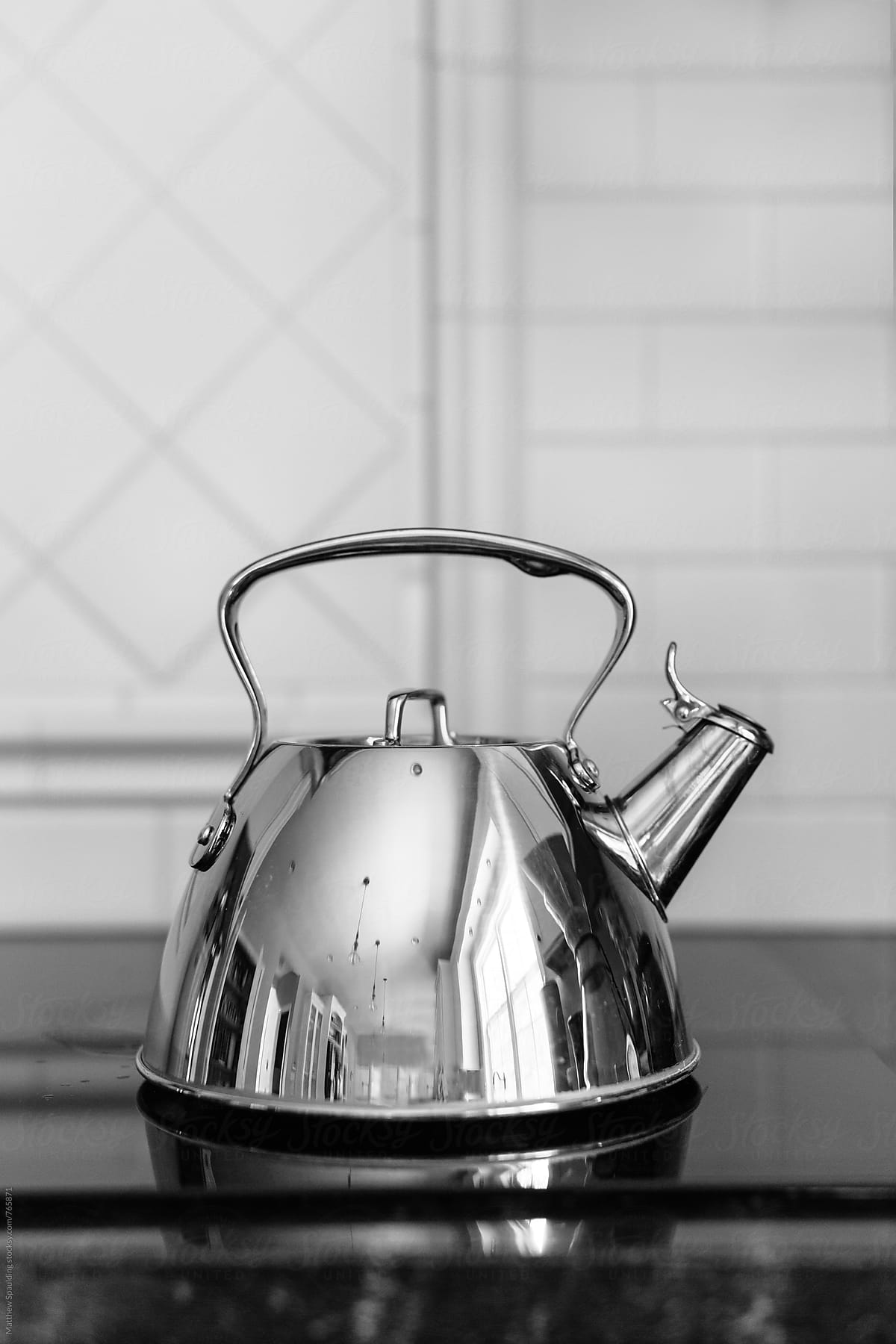 Shiny tea kettle on stove top