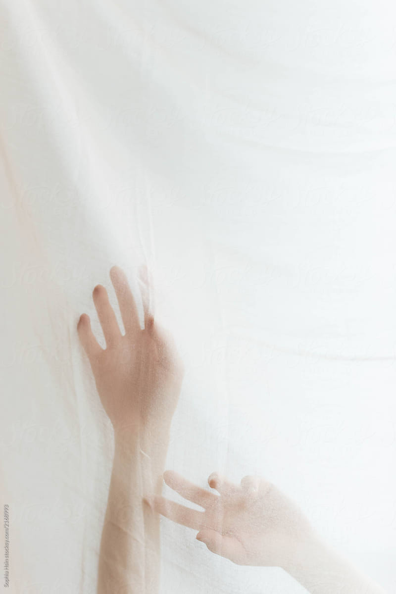 Artistic series of hands moving behind silk