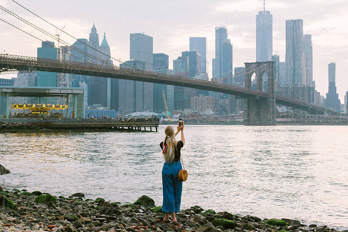 Girl taking a photo of the of Brooklyn Bridge