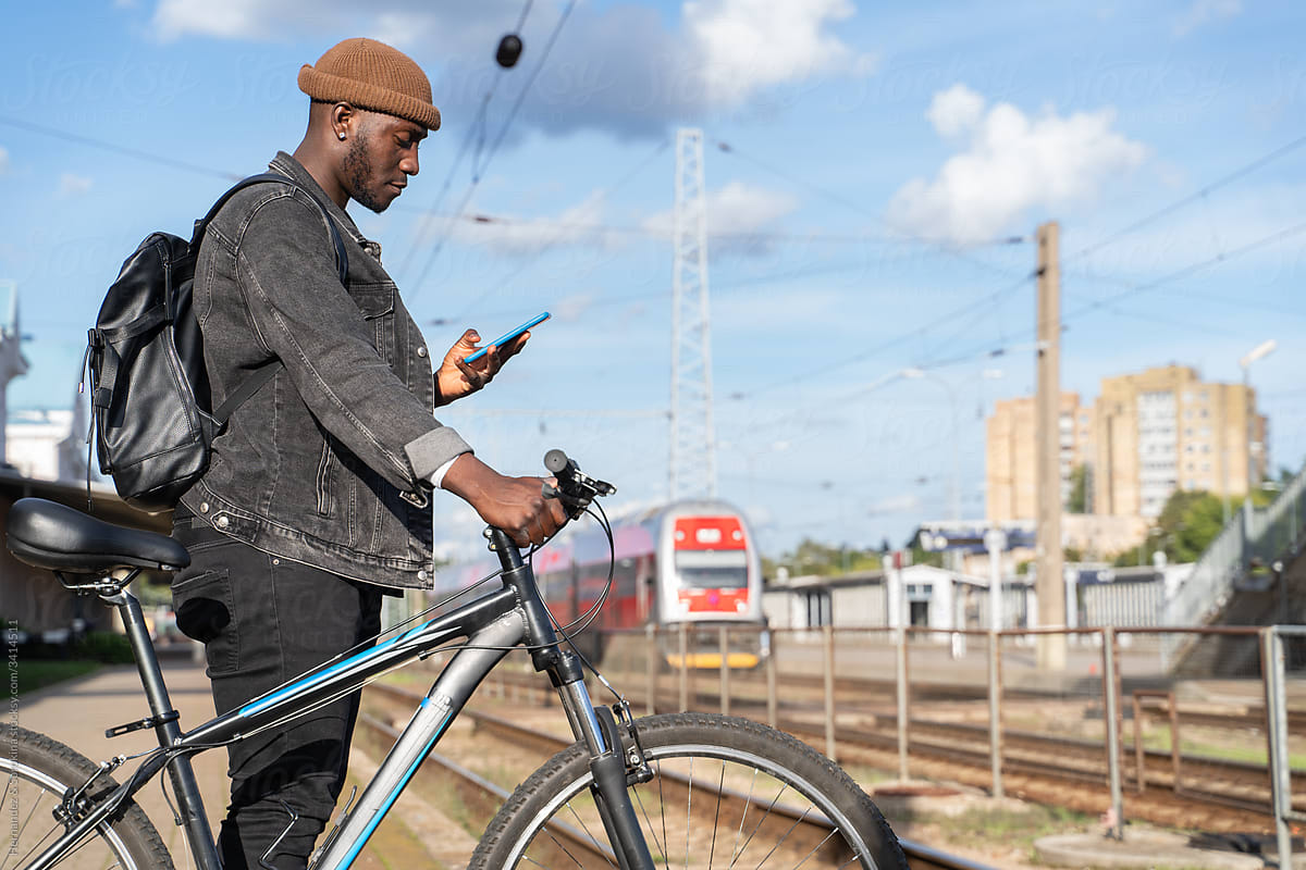 Man With Bicycle And Cellphone In Train Station