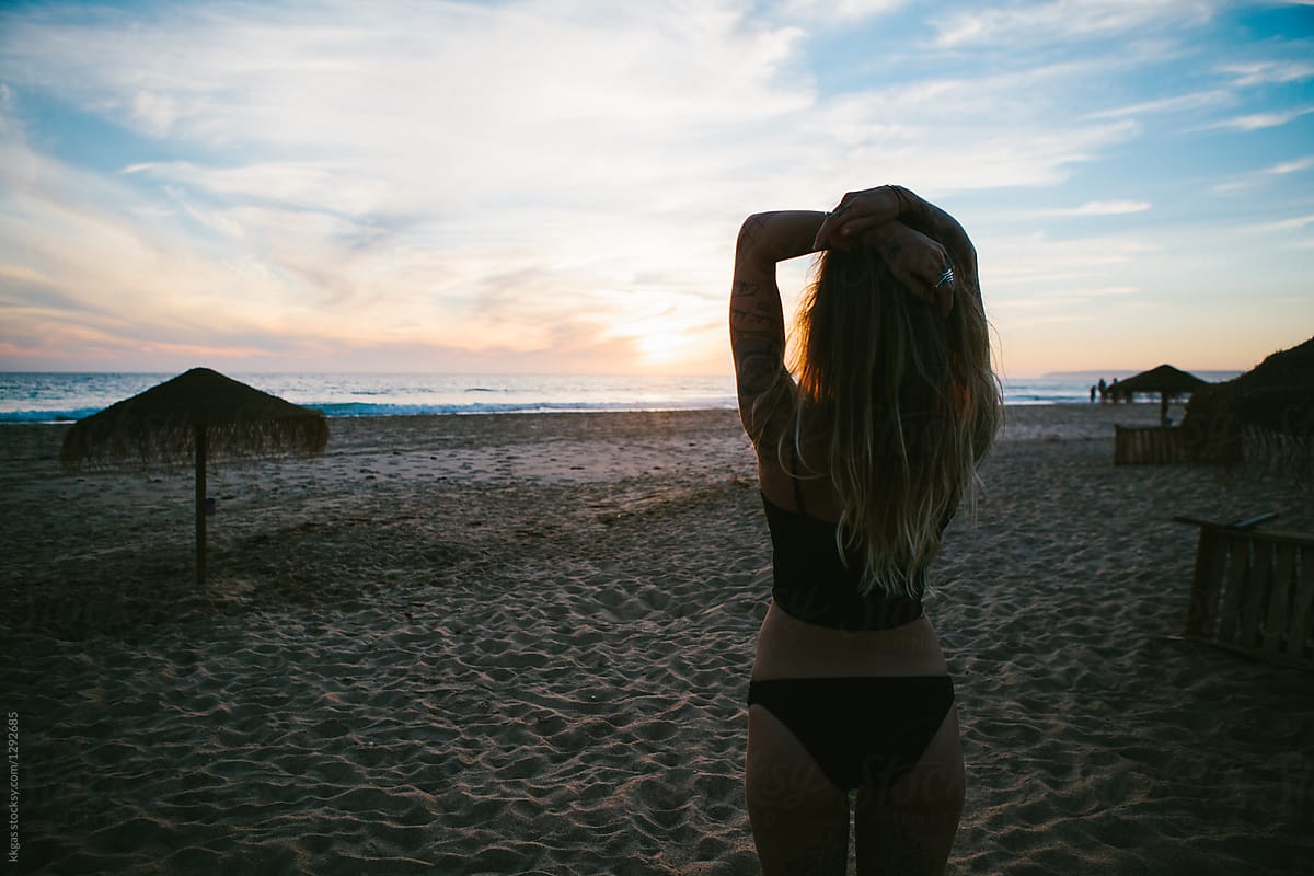Beautiful woman on the beach watching the sunset
