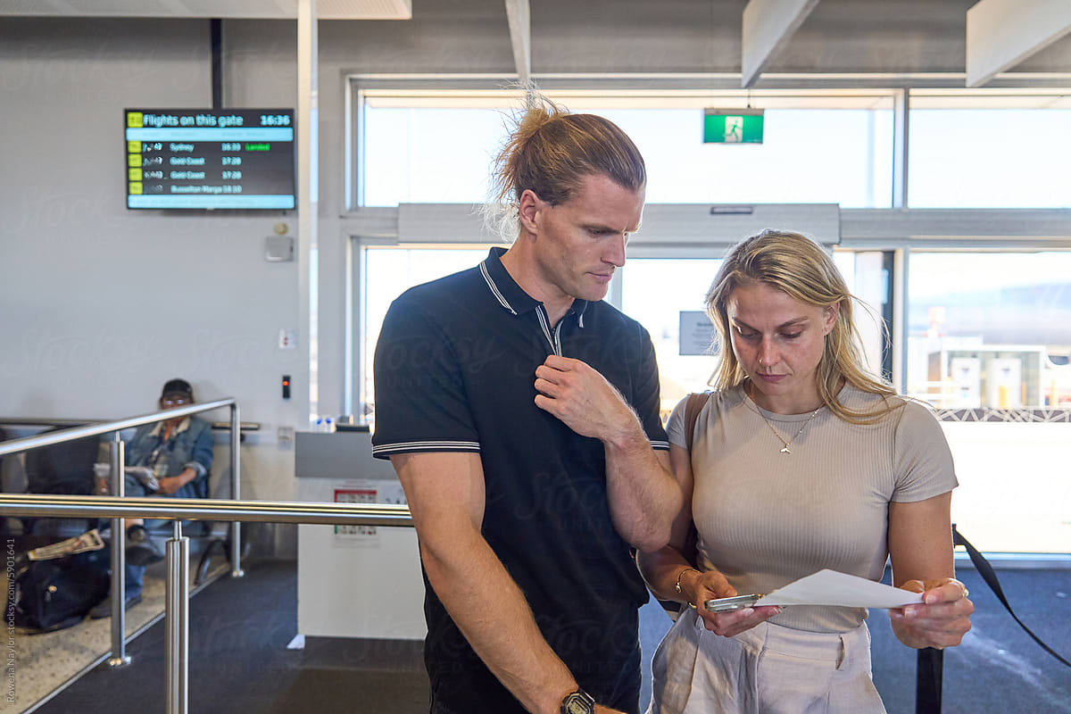 Couple checking travel itinerary at airport