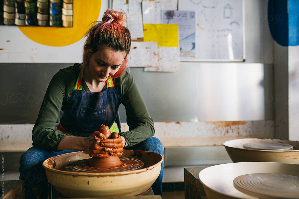 Female potter working with clay on wheel
