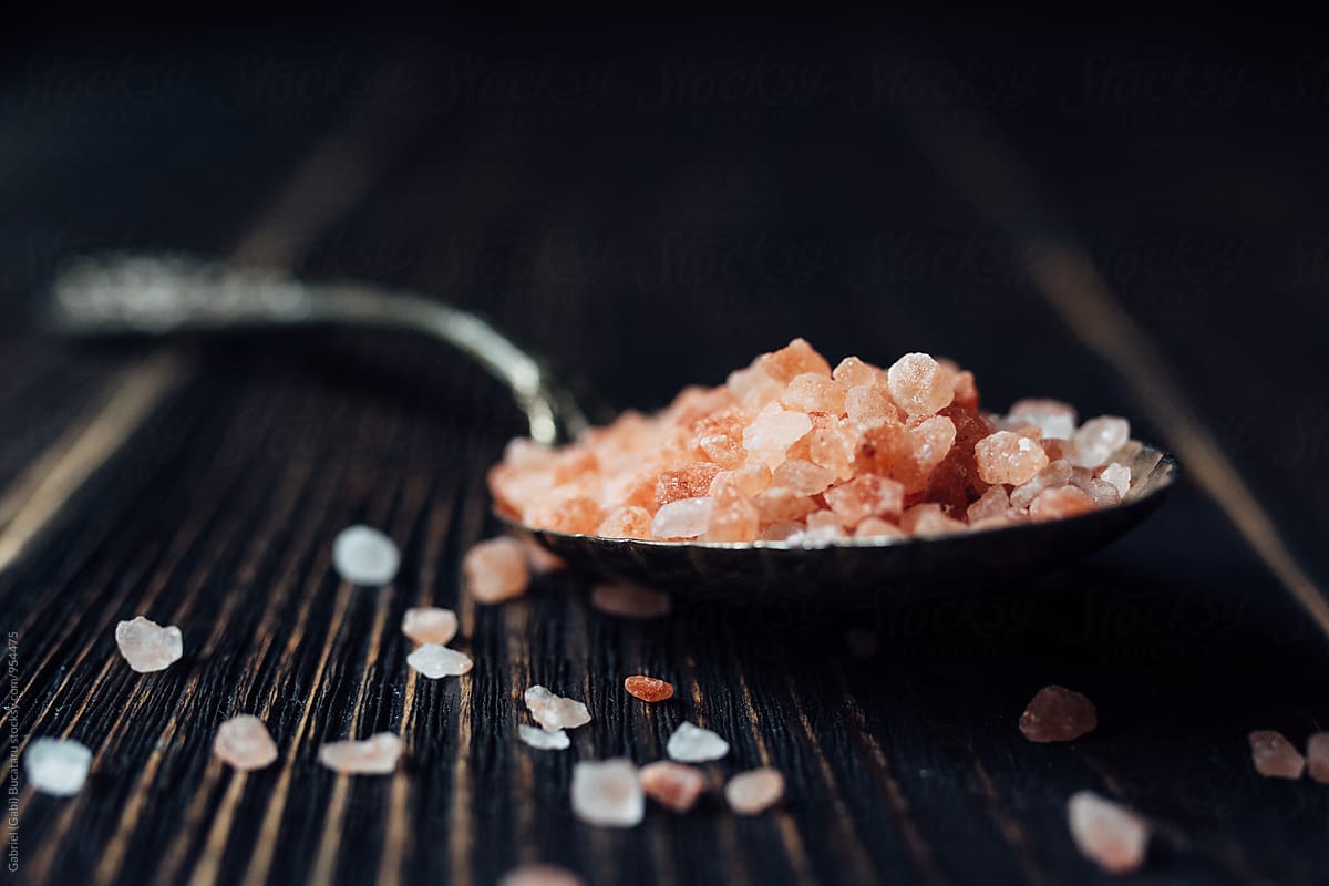 Pink salt crystals in a spoon