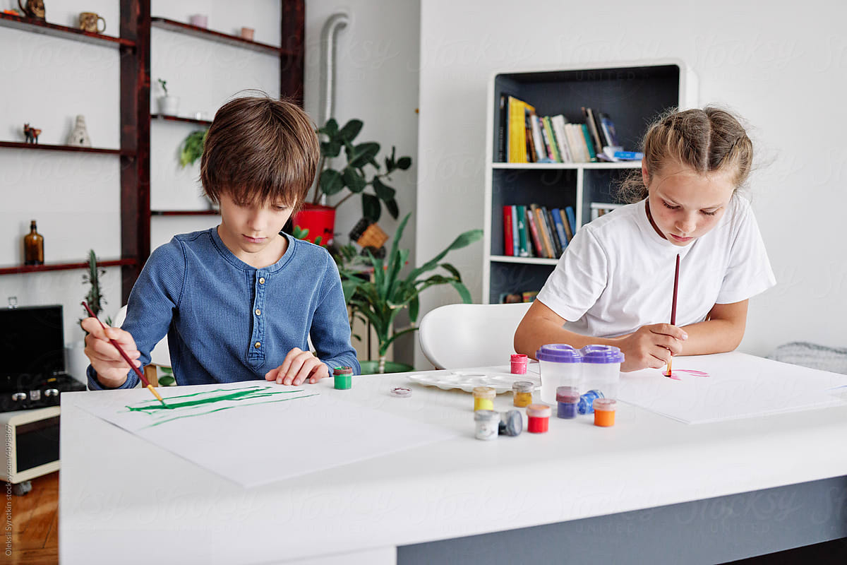 Girl with boy together studying painting at home