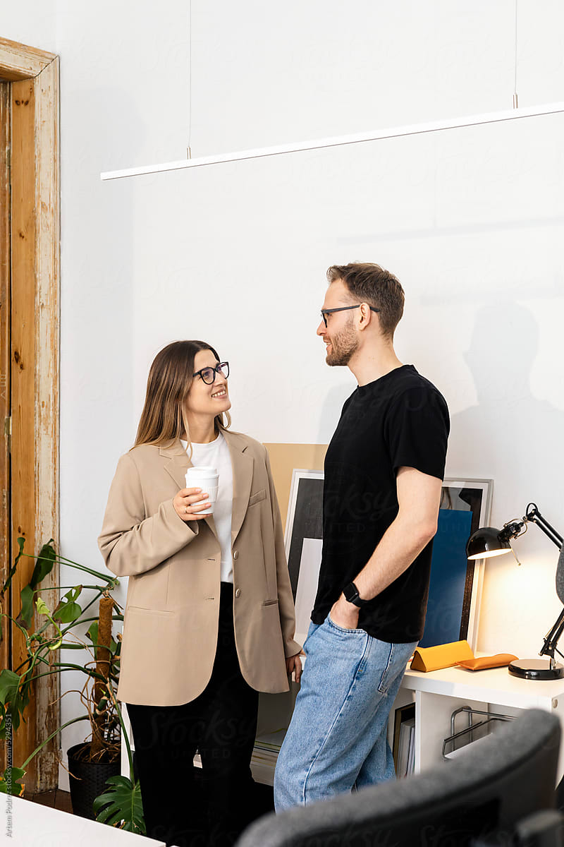 Man and woman chatting and laughing in a modern office