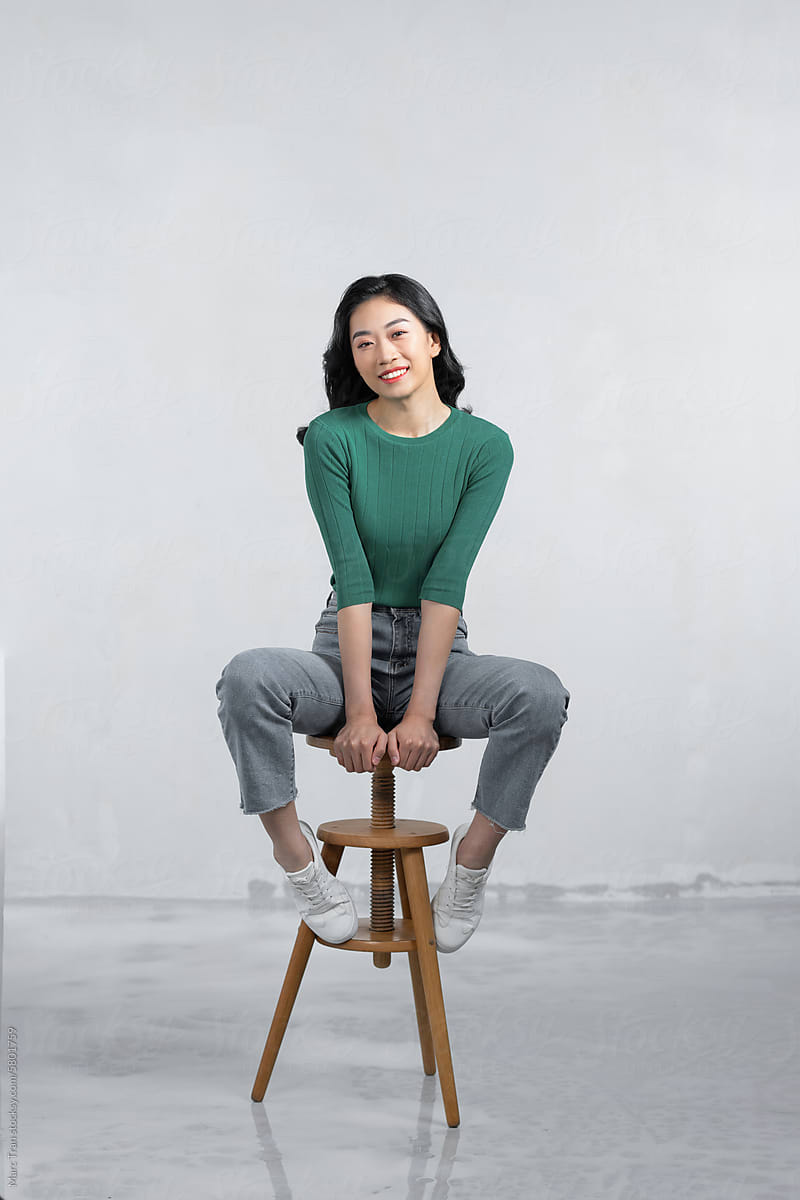 Full-length photo of a gorgeous girl sitting on a bar stool