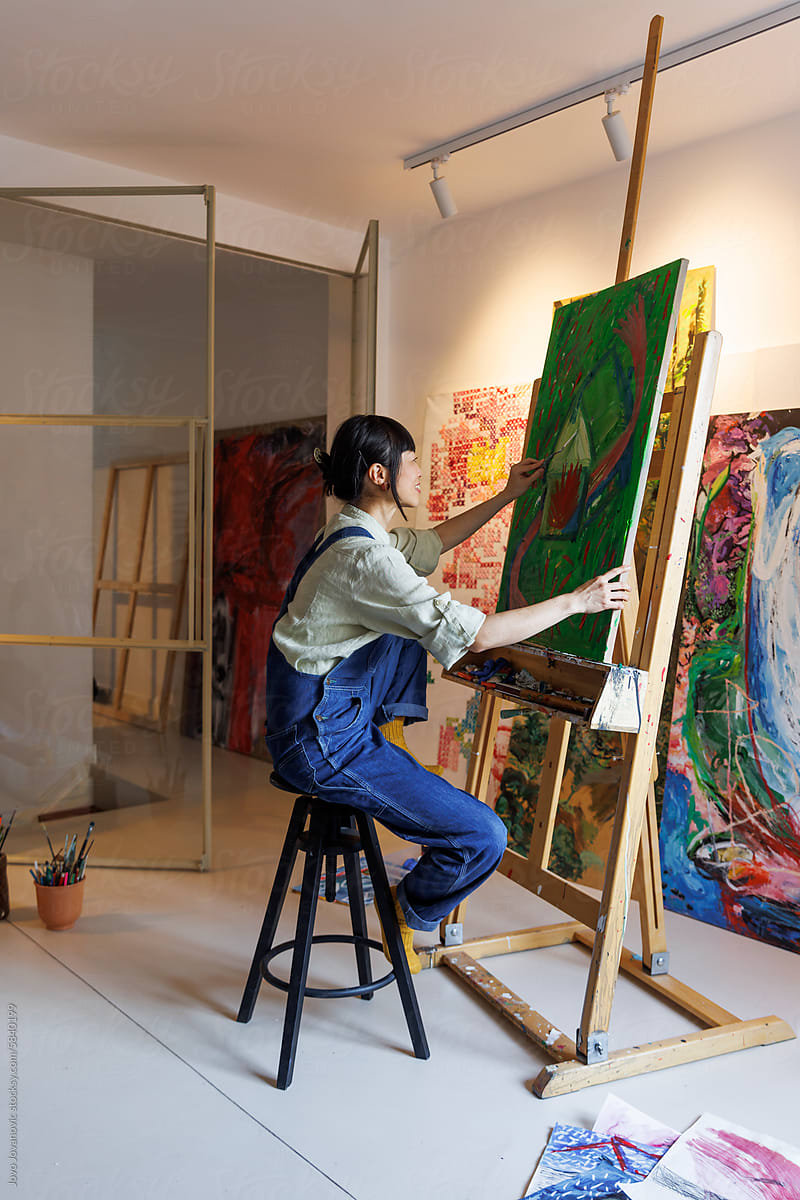 Female painter painting on canvas at art studio