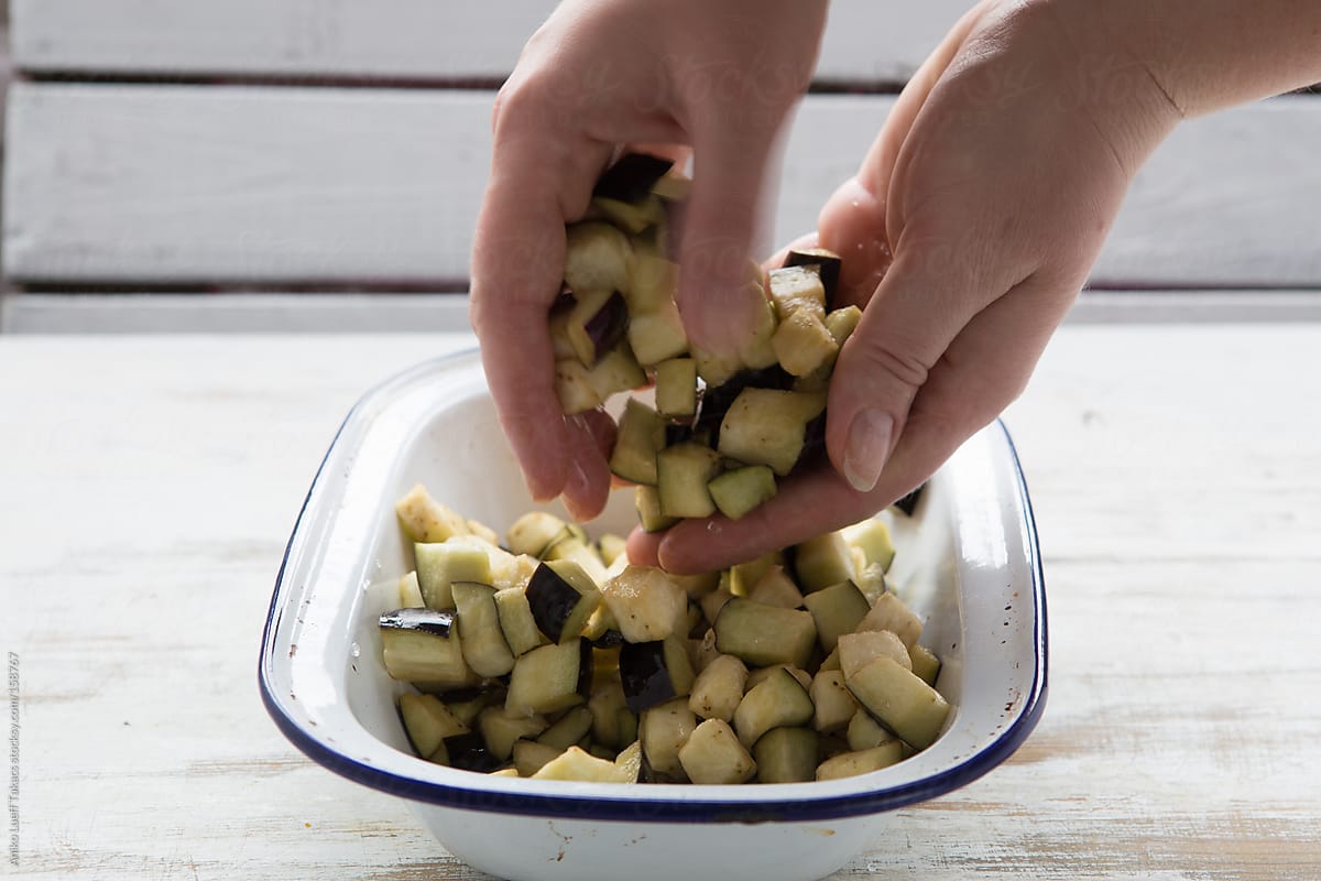 Woman mix the diced aubergine with hand