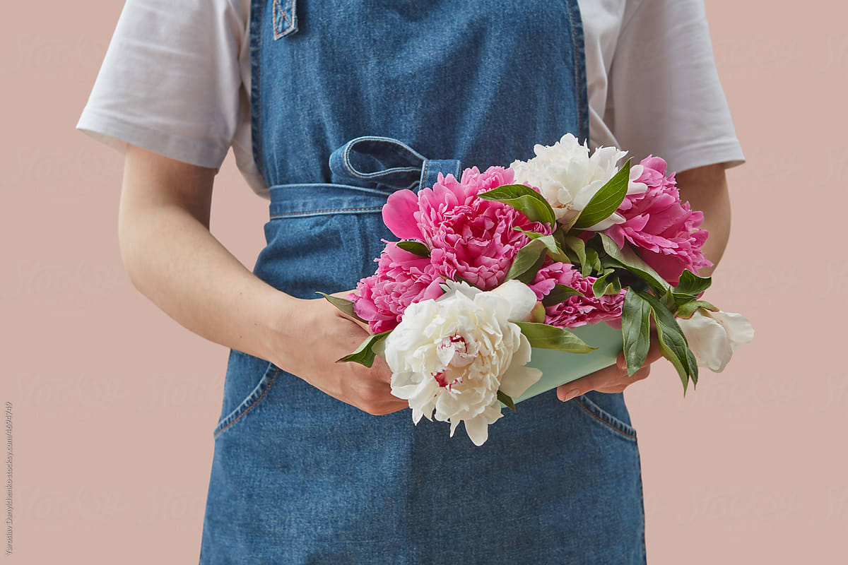 Woman holding bouquet of beautiful peonies.