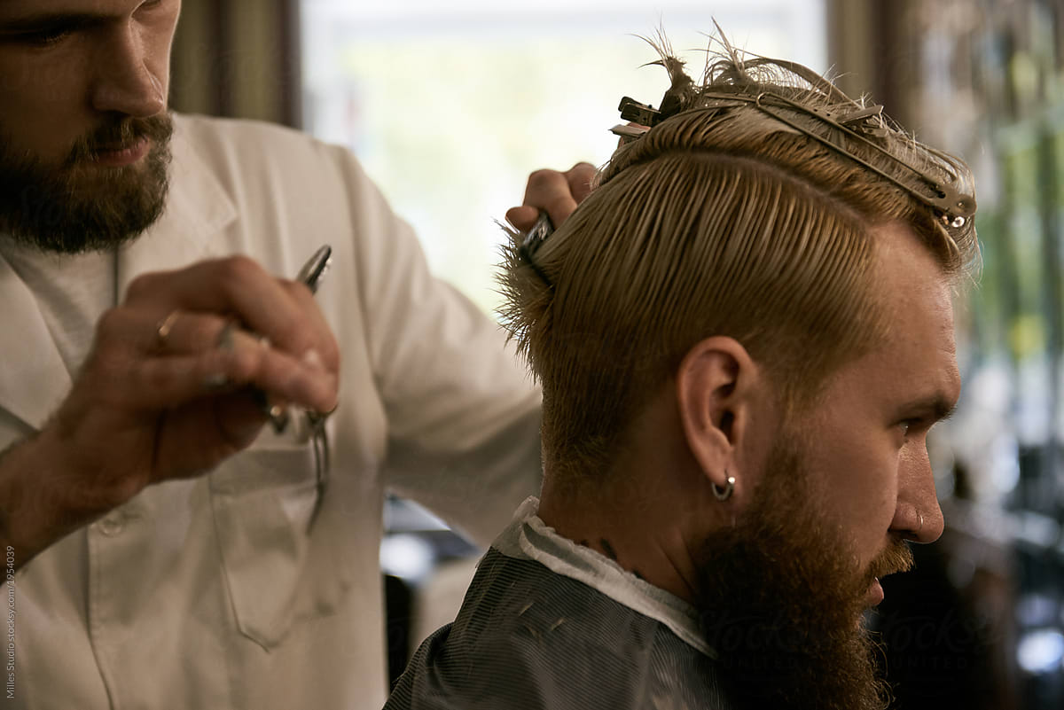 Bearded man having new haircut in barbershop