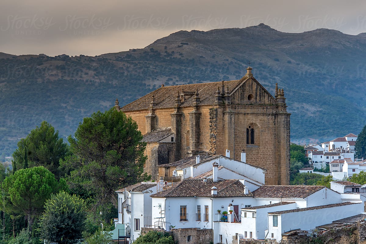 White houses around a church with trees in Spain.
