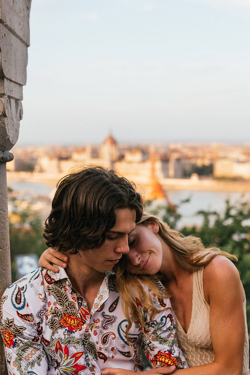 lovely couple embracing together, a blurry city background